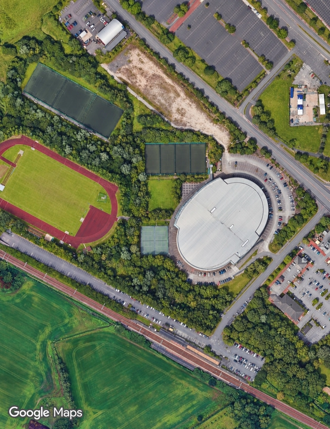 Aerial view of Bolton Arena showing the building, parking and far astroturf pitches in the top-left corner