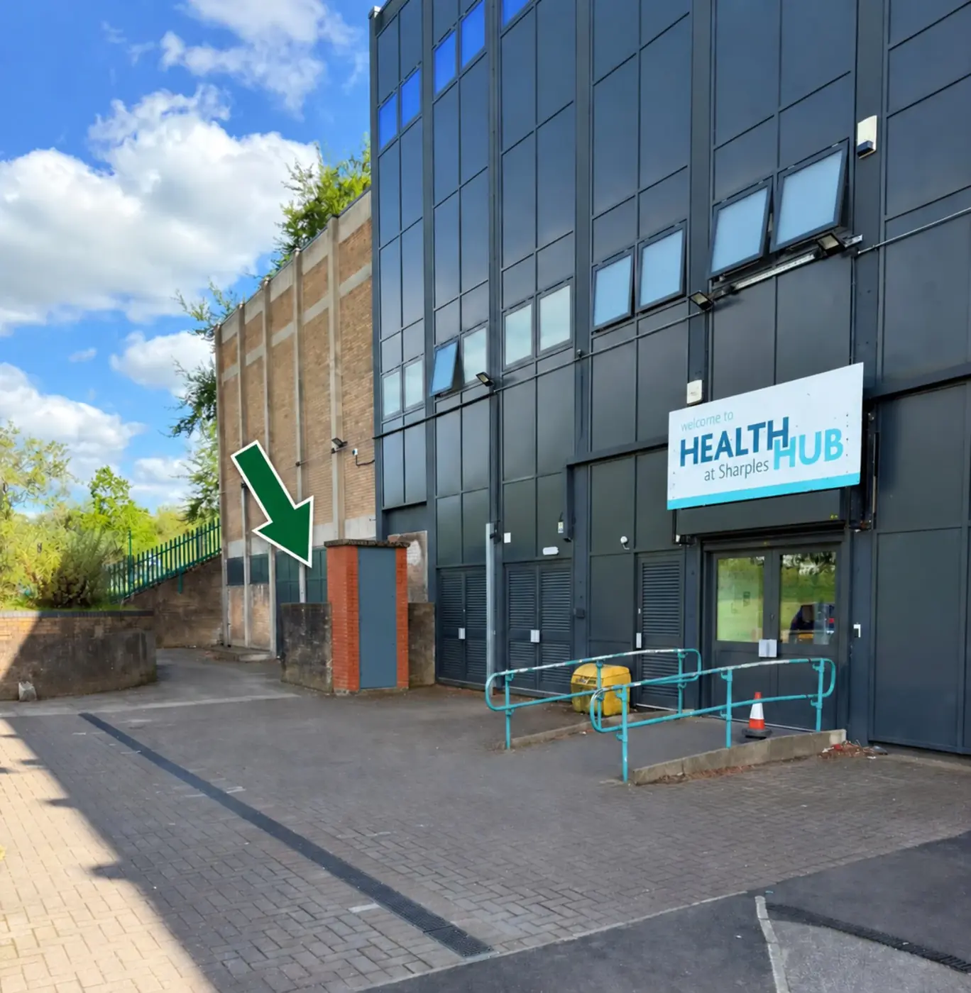 Wide view showing the storeroom location behind the red-brick projection beside the Health Hub