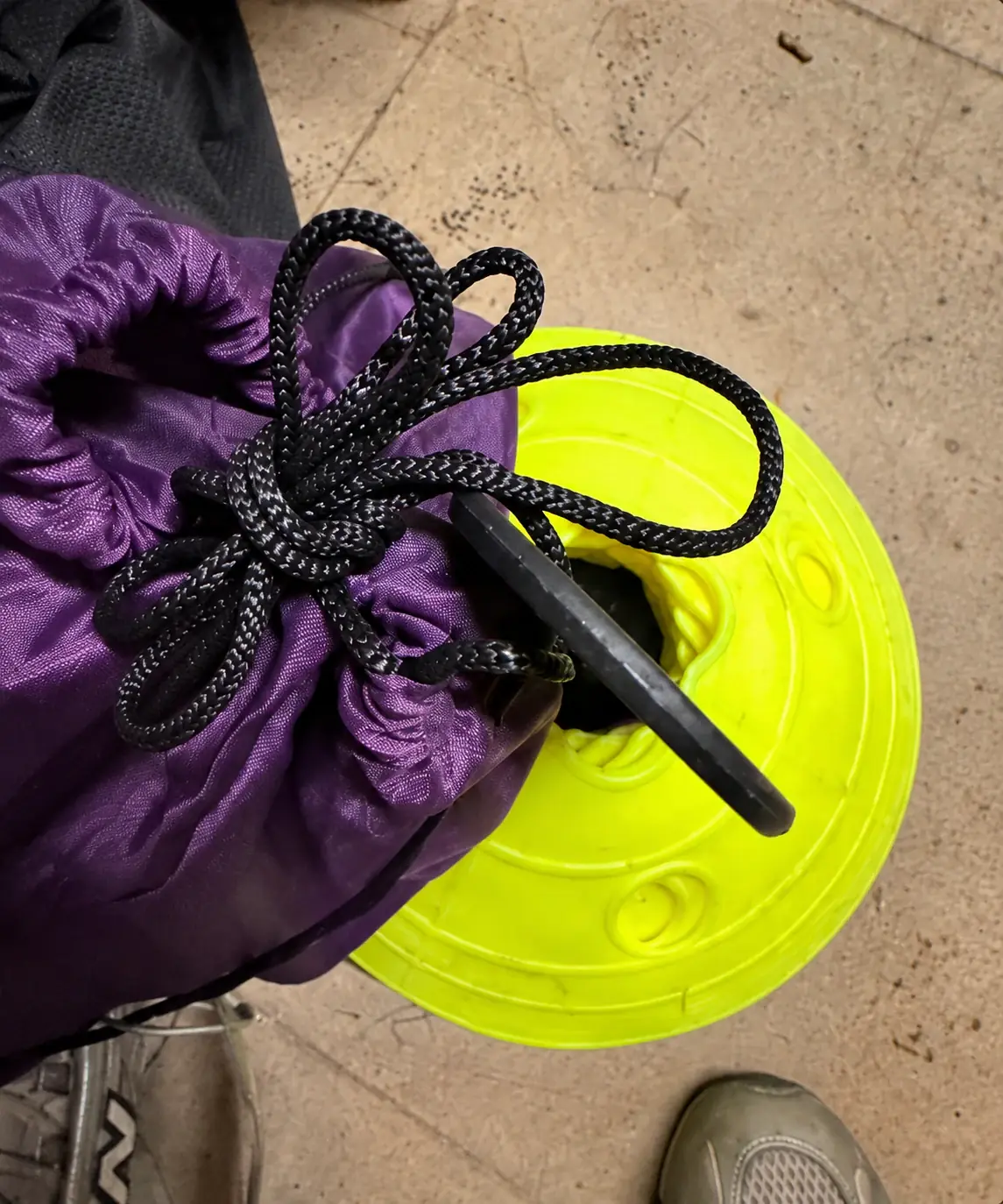 Purple pitch bag tied securely to a stack of yellow cones